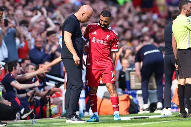 Arne Slot manager / head coach of Liverpool speaks with Mohamed Salah of Liverpool as he goes off injured