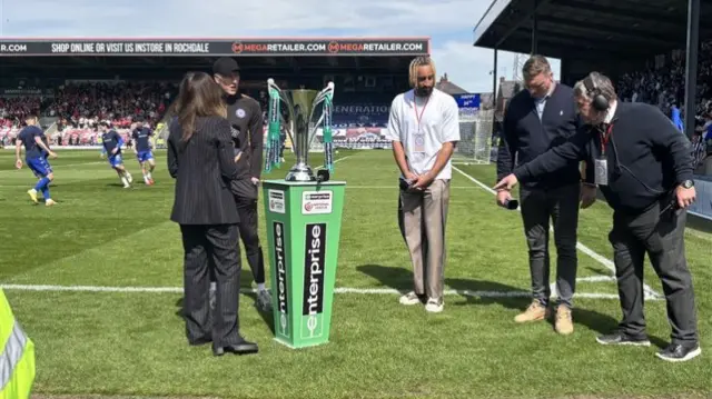 The National League trophy on the pitch at Spotland