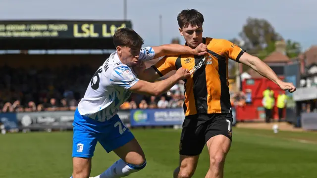 Adam Mayor of Cambridge United in action with Jack Thompson of Barrow