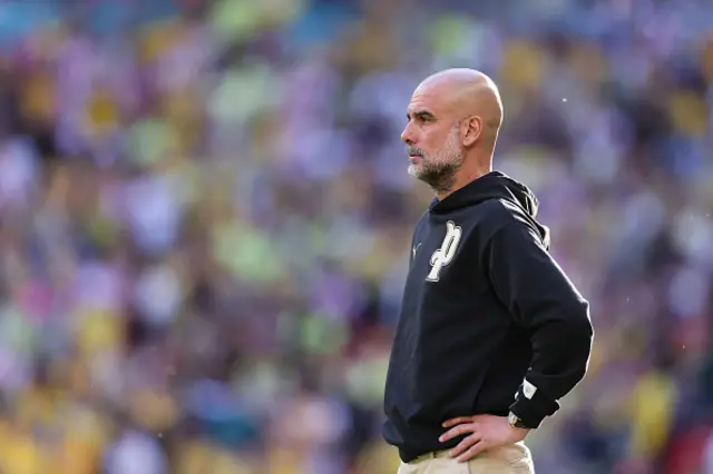 Pep Guardiola, Manager of Manchester City, looks on