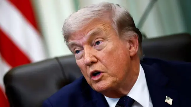 US President Donald Trump speaking from his desk in the Oval Office