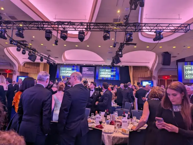 Attendees standing and discussing after the dinner was canceled