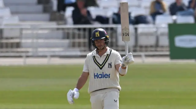 Warwickshire's Michael Booth raises his bat