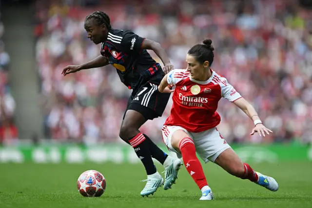 Vicki Becho of OL Lyonnes is challenged by Emily Fox of Arsenal