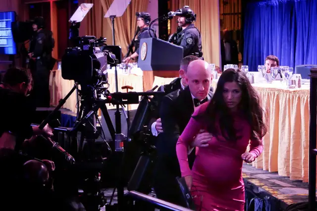 Stephen Miller helps his wife Katie Miller after an incident at the annual White House Correspondents Association Dinner