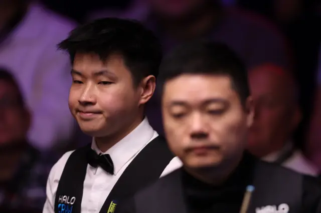 Zhao Xintong of China looks on against Ding Junhui of China during the second round match on day eight of the Halo World Snooker Championship at The Crucible Theatre