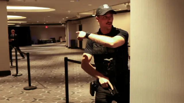 A Secret Service agent gestures at White House Correspondents' Dinner, amid reports of an alleged shooter.
