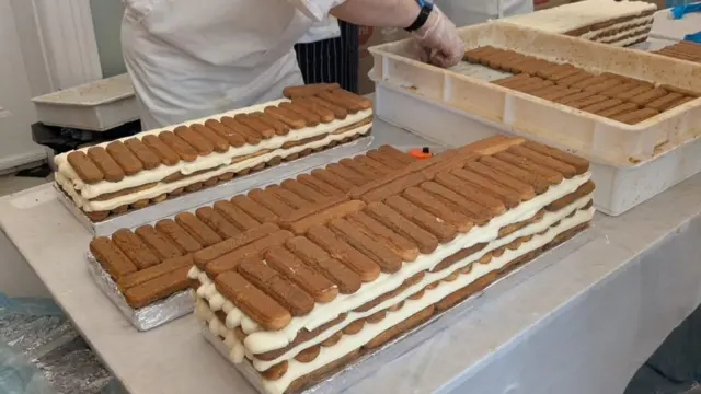A close-up of tiramisu being layered up