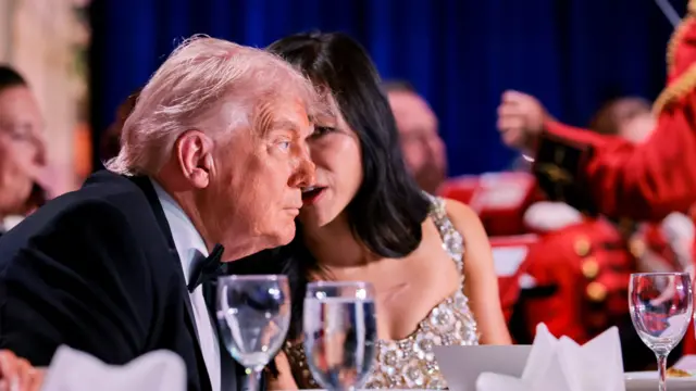US President Donald Trump listens to CBS News senior White House correspondent Weijia Jiang during the annual White House Correspondents' Association dinner in Washington