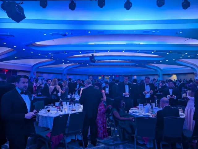 Attendees standing and discussing after the dinner was canceled