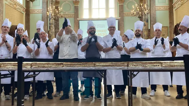 A line of chefs stand behind the world record attempt
