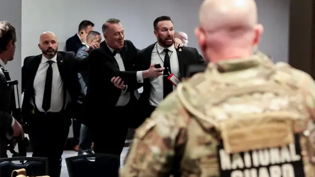 Security officials evacuate guests as a shooter opens fire during the annual White House Correspondents' Association dinner in Washington, D.C., U.S., April 25, 2026.