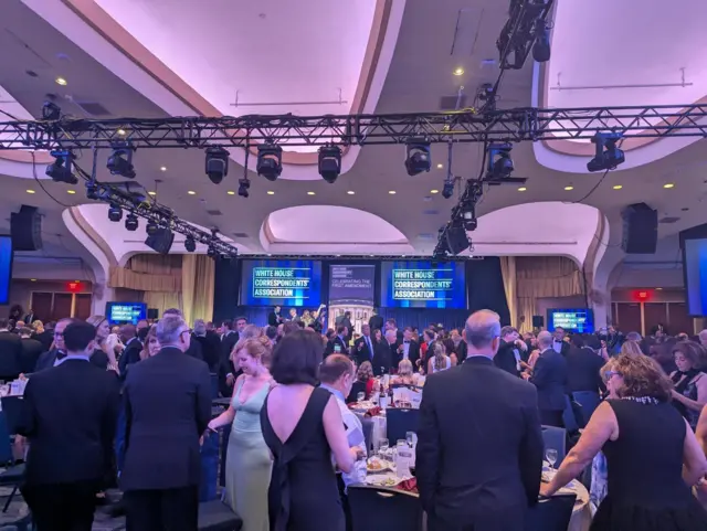 Attendees standing and discussing after the dinner was canceled
