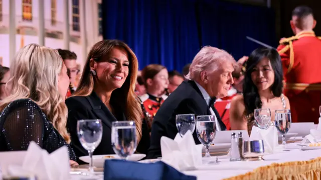 U.S. President Donald Trump, first lady Melania Trump, White House Press Secretary Karoline Leavitt and CBS News senior White House correspondent Weijia Jiang seated at a table during the dinner