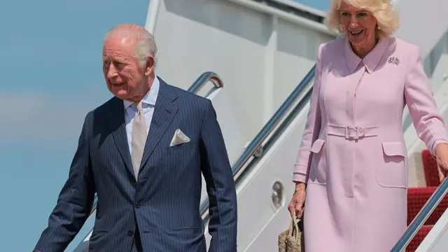 King Charles and Queen Camilla descend the aircraft staircase