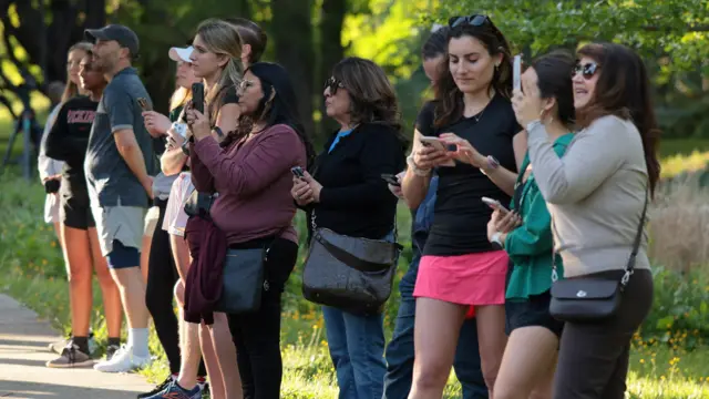 Onlookers stand across the street from the British ambassador’s residence during a garden party honoring Britain’s King Charles and Queen Camilla during their visit to the United States in Washington, D.C., U.S., April 27, 2026. REUTERS/Kylie Cooper