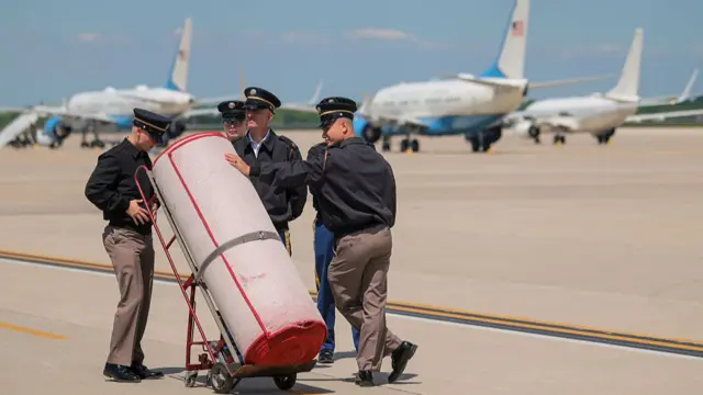 A red carpet is wheeled out on the tarmac