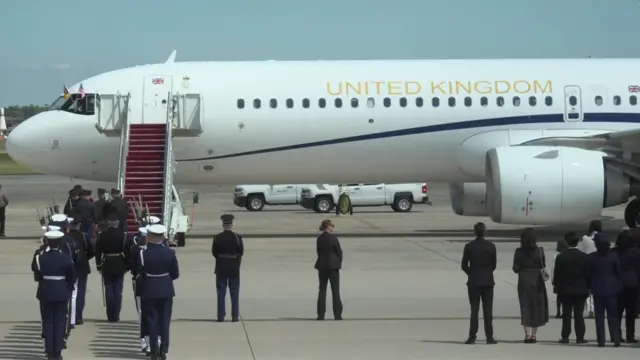 A plane on tarmac, people stood nearby.