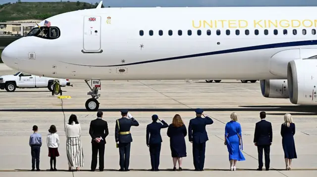 A line of people wait to greet the King and Queen