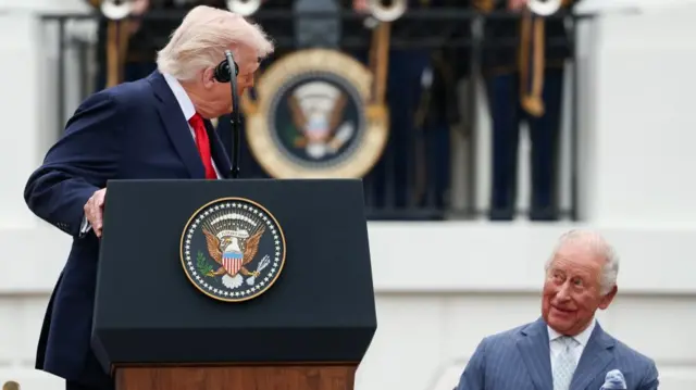 Donald Trump speaking to Kind Charles from a podium outside the White House. The King its behind him.