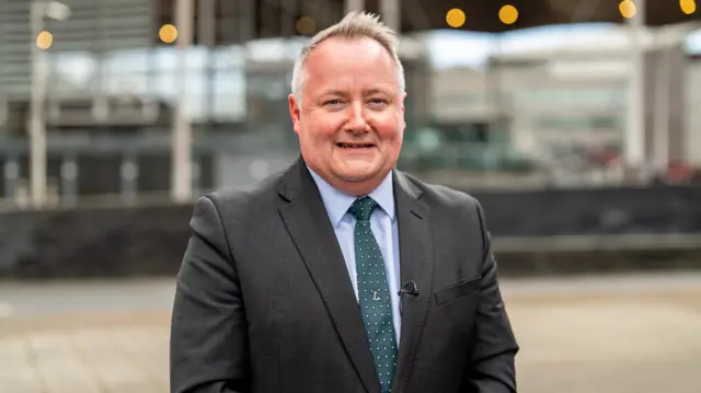 Darren Millar, Welsh Tory leader, smiling wearing a suit and tie