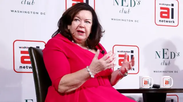 Karen Pierce in red dress speaking at conference