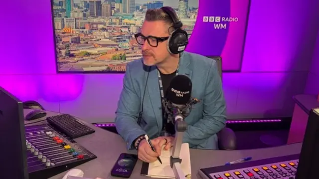 Ed James in a radio booth wearing headphones