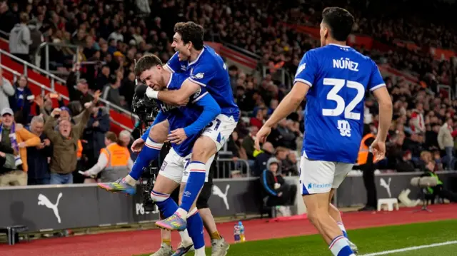 Ipswich players celebrate Wes Burns' goal in front of the travelling support