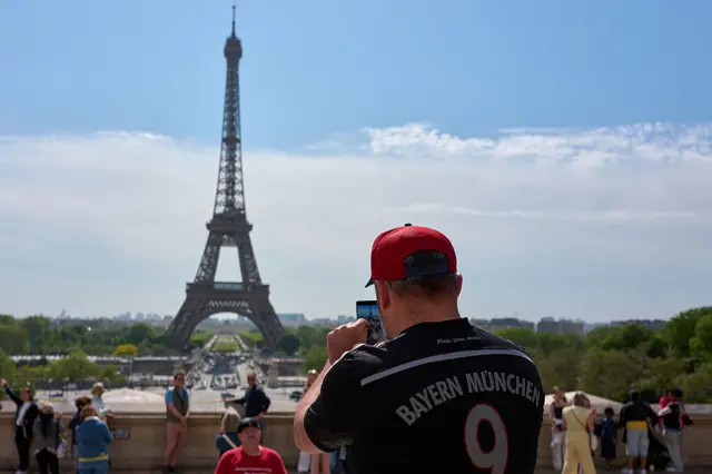 Bayern Munich fan taking a picture of the Eiffel Tower