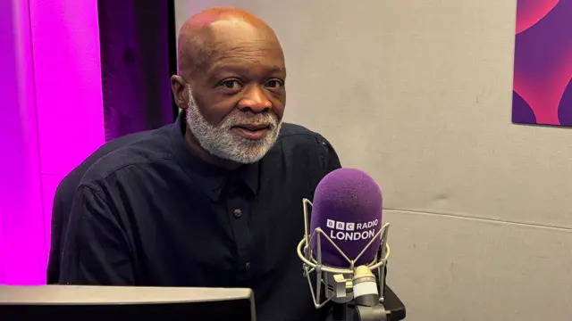 Eddie Nestor in a radio booth in front of a microphone