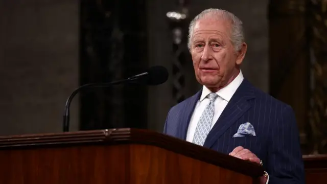 King Charles speaking at a lectern.