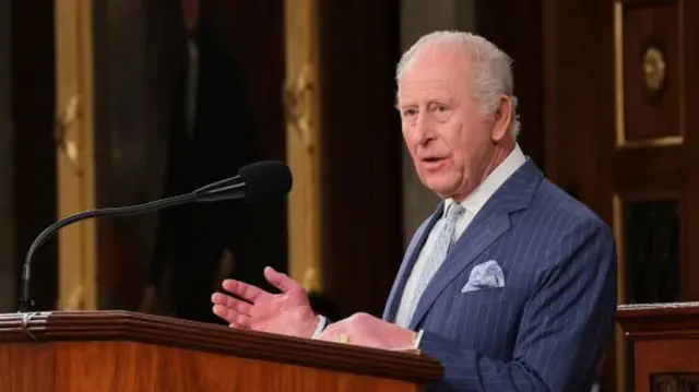 King Charles speaking at a lectern.