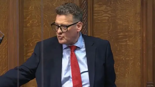 Karl Turner pictured wearing a suit and a red tie