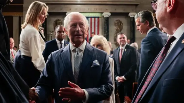 A face-on photo of the King walking through a crowd of people in the US House of Representatives.