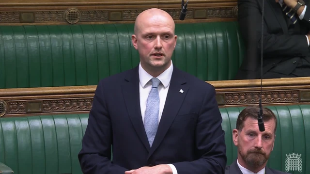 Stephen Flynn pictured at the House of Commons wearing a suit and blue tie
