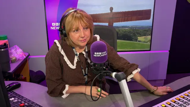 Anna Foster sat in a radio booth wearing headphones