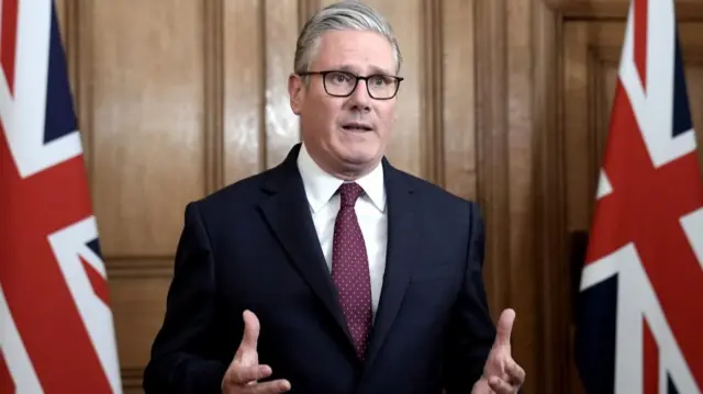 Starmer speaks in between two Union Jacks