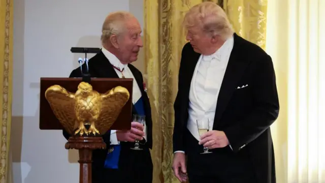 Charles and Trump talk while holding glasses