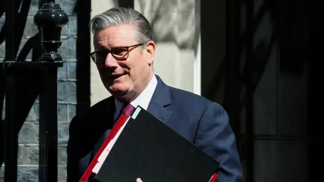 Keir Starmer holds folders