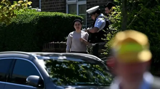 A police officer takes down a statement from a woman