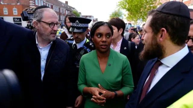 Conservative Party leader Kemi Badenoch at the scene in Golders Green stands among police officers and members of Jewish community