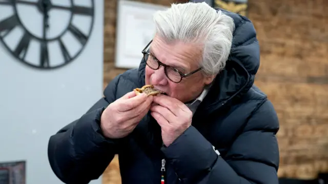 Malcolm Offord eating a Scotch pie