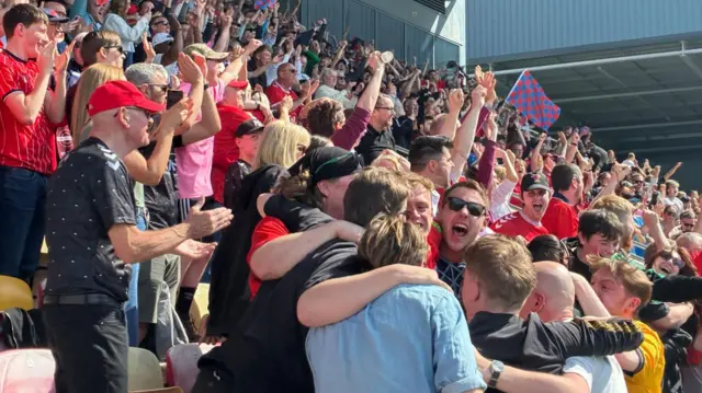 Football fans cheers, smile and hug as their team clinch promotion