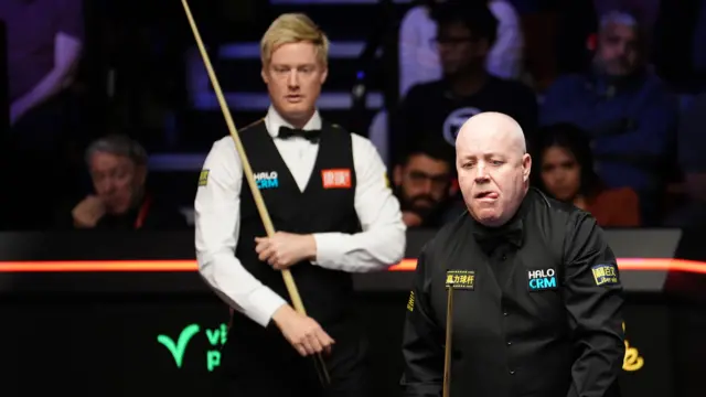 John Higgins looks on with Neil Robertson standing in the background