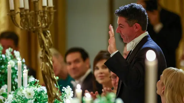 Rory McIlroy waves his hand as he stands at state dinner