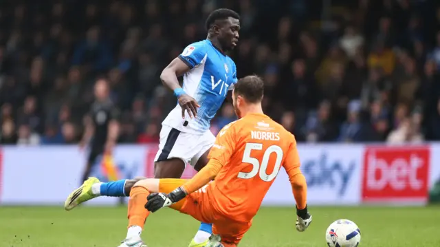 Adam Sidibeh goes around Wycombe goalkeeper Will Norris to score
