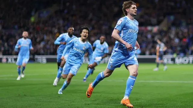 Jack Rudoni runs off to celebrate pursued by his Coventry team-mates
