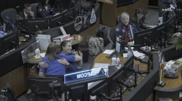 Two women hug at ground control as Artemis II heads towards the Moon.