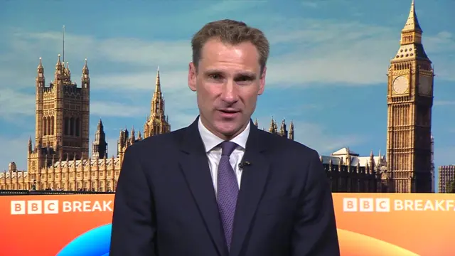 Chris Philp wears a navy suit and purple tie in front of the BBC Breakfast backdrop, which includes the Palace of Westminster