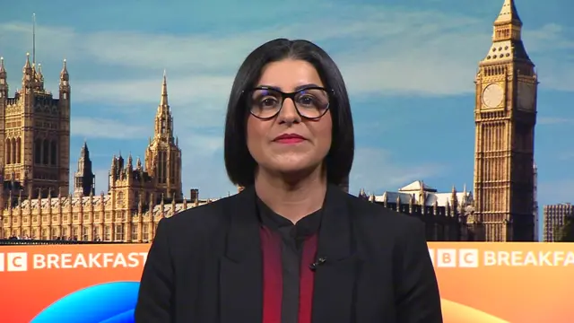 Home Secretary Shabana Mahmood in black blazer and red shirt sits down during an interview in TV studio